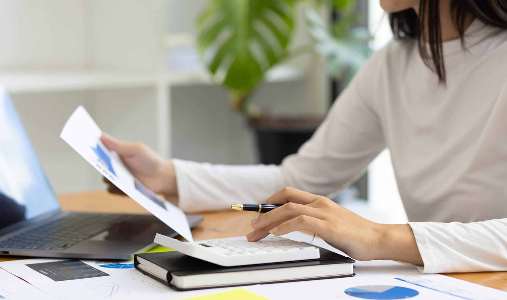 Image - Female accountant in office calculating and analyzing financial accounts.
